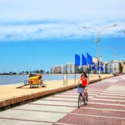 Woman riding bike along beach in Uruguay